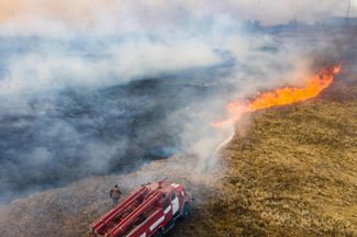 Firefighters work to put out a grass fire. April 10, 2020