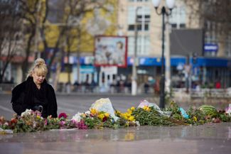 Жительница Херсона возле импровизированного мемориала памяти погибшим во время российской оккупации города