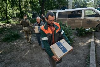 Волонтеры несут коробки с гуманитарной помощью в «пункт несокрушимости» — так в Украине называют специально оборудованные укрытия, где люди могут согреться, поесть и зарядить технику