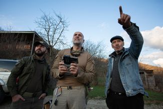 Участники движения запускают дрон в сторону территории Южной Осетии. Местный житель показывает им, где он недавно видел российских военных