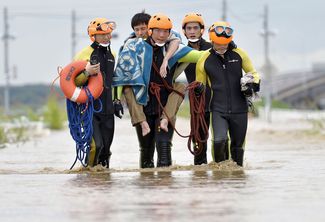 Пожарные несут пострадавшего в результате наводнения, 10 сентября 2015 года