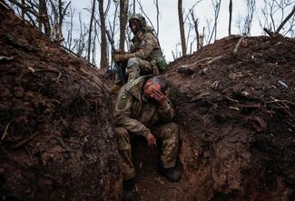 Украинские военные отдыхают в окопе в перерыве между боем. 