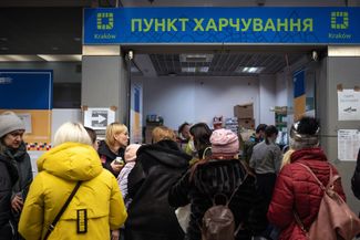 Украинские беженцы стоят в очереди в пункте гуманитарной помощи. На главном железнодорожном вокзале польского Кракова они ждут поездов, чтобы ехать дальше. 13 марта 2022 года