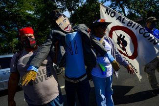 Протестующие в Сан-Сальвадоре держат куклу, изображающую президента Букеле. 17 октября 2021 года
