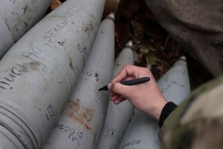 Военный делает надписи на снарядах