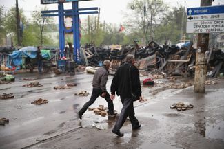 Residents walk through the barricaded area around the SBU building in Luhansk. April 30, 2014.