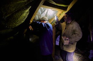 Житель Котляров чинит крышу поврежденного дома