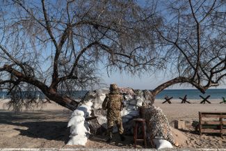 Украинский солдат следит за морем на пляже в Лузановке — районе Одессы