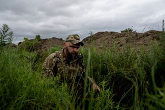 Украинский солдат в окопах к югу от Харькова. Власти города утверждают, что Россия не отказалась от планов оккупации