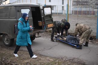 Украинские военнослужащие готовят к погрузке тело убитого солдата