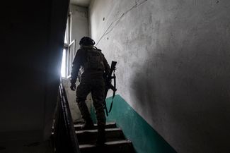 Украинский военный из «Айдара» обходит здание возле линии фронта на бахмутском направлении