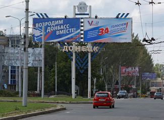 Баннеры «Возродим Донбасс вместе!» и «Голосуем за Донбасс!», посвященные грядущим парламентским выборам в самопровозглашенных ДНР и ЛНР. Они намечены на 10 сентября