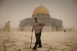 Палестинец в защитной маске рядом с мечетью Купол Скалы на Храмовой горе в Иерусалиме, 8 сентября 2015 года