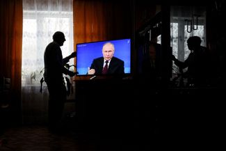 Москвич смотрит прямую трансляцию итоговой пресс-конференции президента России Владимира Путина у себя дома