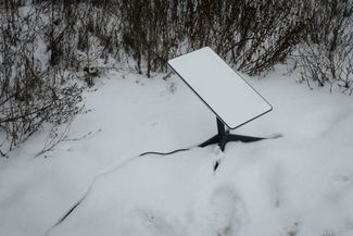 Антенна спутниковой широкополосной системы Starlink в снегу. Компания SpaceX поставляет интернет-оборудование в Украину с начала полномасштабного вторжения. Starlink — важная часть коммуникаций ВСУ