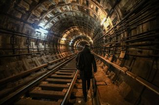 A Kharkiv resident walks from one station to another through a subway tunnel