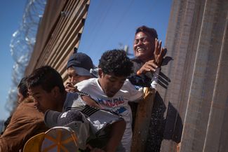 Мигранты возвращаются на мексиканскую сторону границы после неудачной попытки проникнуть на территорию США