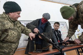 Участники Сил территориальной обороны — добровольческого формирования в составе Вооруженных сил Украины — учатся собирать автомат Калашникова