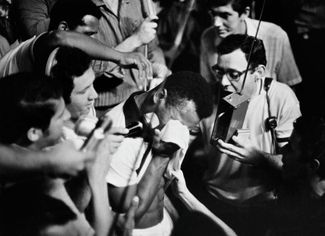 Пеле плачет в окружении журналистов после забитого с пенальти 1000-го гола в карьере — это произошло в матче «Сантоса» против «Васко да Гама» на стадионе «Маракана» в Рио-де-Жанейро 19 ноября 1969 года.Этого момента долго ждали болельщики и, по собственным словам Пеле, подходя к «точке», он впервые в карьере не мог справиться с нервами и трясся от волнения. «Конечно, тысячный гол я надеялся забить не с пенальти, — <a href="https://www.championat.com/football/article-4025333-kak-pele-zabil-tysjachnyj-gol-istorija-legendy-futbola-video.html" rel="noopener noreferrer" target="_blank">писал</a> футболист в своих воспоминаниях. — Но в тот момент я был мысленно согласен и с таким вариантом. Оглушительный крик стадиона, казалось, остановил дождь, не прекращавшийся в течение всего матча. Из-за ворот ко мне бросилась толпа фотокорреспондентов. Вслед ринулись сотни зрителей с трибун, не обращая внимания на полицию. Болельщики неслись по мокрой траве прямо ко мне. Кто-то сорвал с меня футболку и протянул другую, с огромной цифрой 1000. Потом меня подняли на плечи и понесли по полю. От волнения у меня выступили слезы. Толпы людей выкрикивали приветственные возгласы. Наконец меня опустили на землю, по требованию публики я неторопливо пробежался вокруг поля, чтобы все могли видеть мою юбилейную футболку».