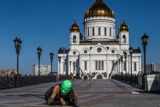 Nadezhda Tolokonnikova in a balaclava in front of the Christ the Savior Cathedral. Shots from an unreleased music video for a collaboration with Tom Morello. 2015.