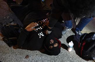 Раненый протестующий лежит на земле в Фергюсоне.