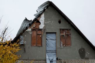 Разрушенный дом с окнами, заколоченными комнатными дверями