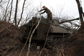 Украинский артиллерист снимает ветки с танка под Лисичанском на западе Луганской области