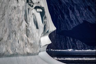 Тающий айсберг дрейфует во фьорде Скорсби в Гренландии