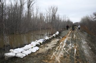 Мешки с песком для защиты от разлива воды на обочине дороги в районе Орска, 8 апреля 2024 года