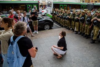 Несанкционированная акция в поддержку Ивана Голунова. Демонстрантка позирует для фото на фоне оцепления, июнь 2019