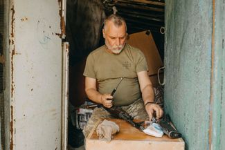 Украинский военнослужащий из 35-й бригады чистит автомат AK-74