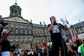 Участник акции солидарности в Амстердаме в футболке со словами «Black Lives Matter» — главным символом расовых протестов. 1 июня 2020 года