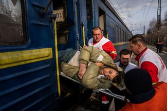 Работники организации «Врачи без границ» несут мужчину в медицинский поезд в Покровске — состав эвакуирует пациентов с линии фронта в более безопасные районы. Покровск расположен примерно в 70 километрах от Бахмута и находится под контролем Украины