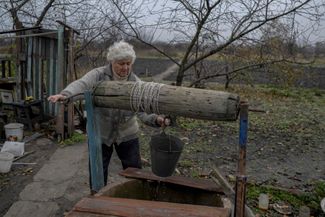 Жительница села Ямполь Донецкой области неподалеку от линии фронта набирает воду из колодца. Ямполь освобожден ВСУ 30 сентября, в селе до сих пор нет ни света, ни воды