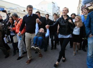 Навальный стал популярной фигурой в конце 2000-х, <a href="https://rus.ozodi.org/a/26769014.html" rel="noopener noreferrer" target="_blank">рассказывая</a> о хищениях в госкорпорациях. Но в общепризнанного лидера российского оппозиционного движения он превратился во время <a href="https://meduza.io/feature/2021/12/05/10-let-nazad-v-moskve-nachalis-samye-massovye-i-optimistichnye-protesty-protiv-putina-togda-kazalos-chto-on-deystvitelno-skoro-uydet" rel="noopener noreferrer" target="_blank">протестов</a> 2011–2012 годов. Тогда же Навальный получил свои первые «сутки». На этом снимке он с женой и сыном Захаром 24 мая 2012-го, после второго ареста на 15 суток. Юлия не скрывала от детей, что Алексей занимается политикой и время от времени попадает из-за этого в тюрьму. По ее <a href="https://tvrain.tv/teleshow/parfenov/julija_navalnaja_deti_znajut_gde_papa_kogda_ego_sa-341087/" rel="noopener noreferrer" target="_blank">словам</a>, их дочь Даша в детском саду говорила про работу отца так: «Папа работает на митингах».