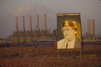 Позолоченный портрет Муаммара Каддафи возле завода по переработке нефти и газа в Триполи. Март 2000 года