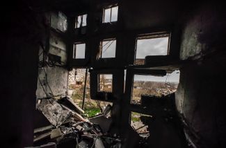Вид на поврежденный жилой дом в селе Архангельское из разрушенного местного профессионального училища