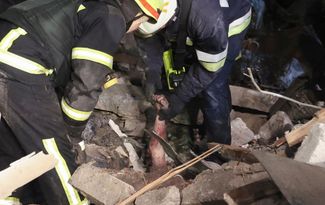 Спасатели вытаскивают из-под завалов тело погибшего жителя девятиэтажки в Днепре