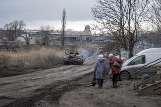 Мирные жители и танк украинских военных на дороге в селе Первая Новоселовка в 20 километрах к северо-западу от Авдеевки