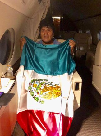Моралес позирует с флагом Мексики на борту самолета мексиканских ВВС