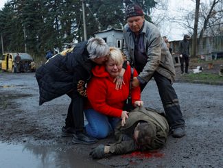 Жительница Донецка плачет у тела своего родственника, погибшего во время обстрела ВСУ