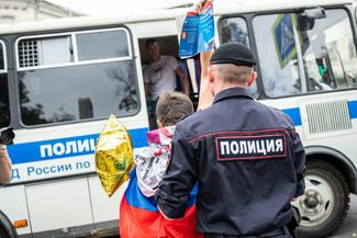 A protester holds up a copy of the Russian Constitution during their arrest.