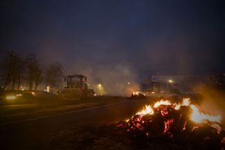 Французские фермеры в Бурже перекрыли съезд с шоссе тракторами, горящей соломой и навозом