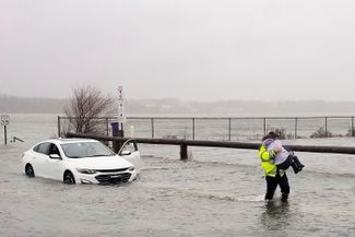 Уэлс, штат Мэн, США. Полицейский спасает женщину, чей автомобиль сломался во время зимнего шторма. 23 декабря 2022 года
