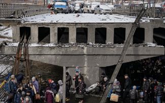 Брошенные автомобили на разрушенном мосту, под которым люди покидают город Ирпень. 8 марта 2022 года