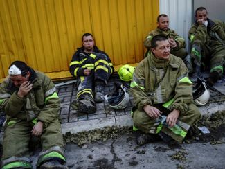 Украинские пожарные отдыхают после ликвидации последствий российского ракетного удара