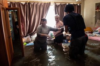Семья из Херсона спасает важные вещи в своем затопленном жилье. 7 июня 2023 года