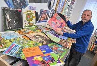 Frankfurt an der Oder music store owner Helmut Schmolke shows off his collection of about 40 recordings from the fairy tale 