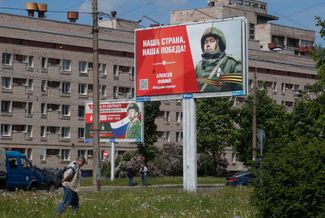A man walks by billboards plastered with recruitment ads. St. Petersburg, Russia. June 8, 2023.