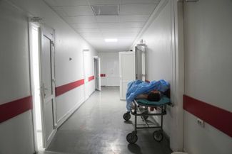 The body of a victim of shelling in a residential area of Mariupol lies in the corridor of a maternity hospital that has been converted into a treatment ward. 